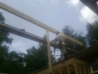 Carpenter setting a ridge beam over a new addition frame — Ice Dam Removal by Roofing Brothers in Verden