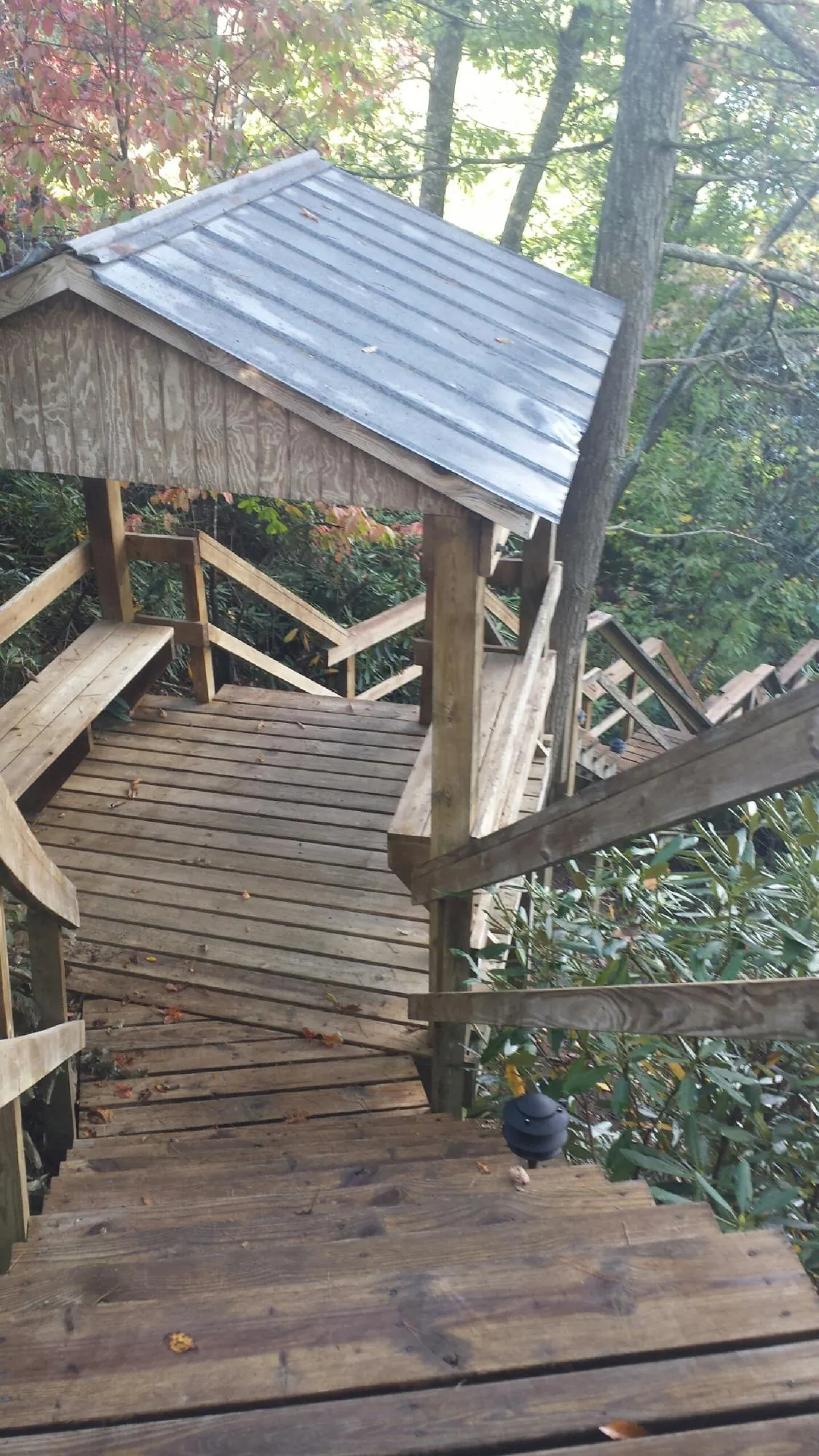 Metal roofed shelter over wooden steps on a wooded walkway — Skylight Repair & Installation work by our crew in Verden