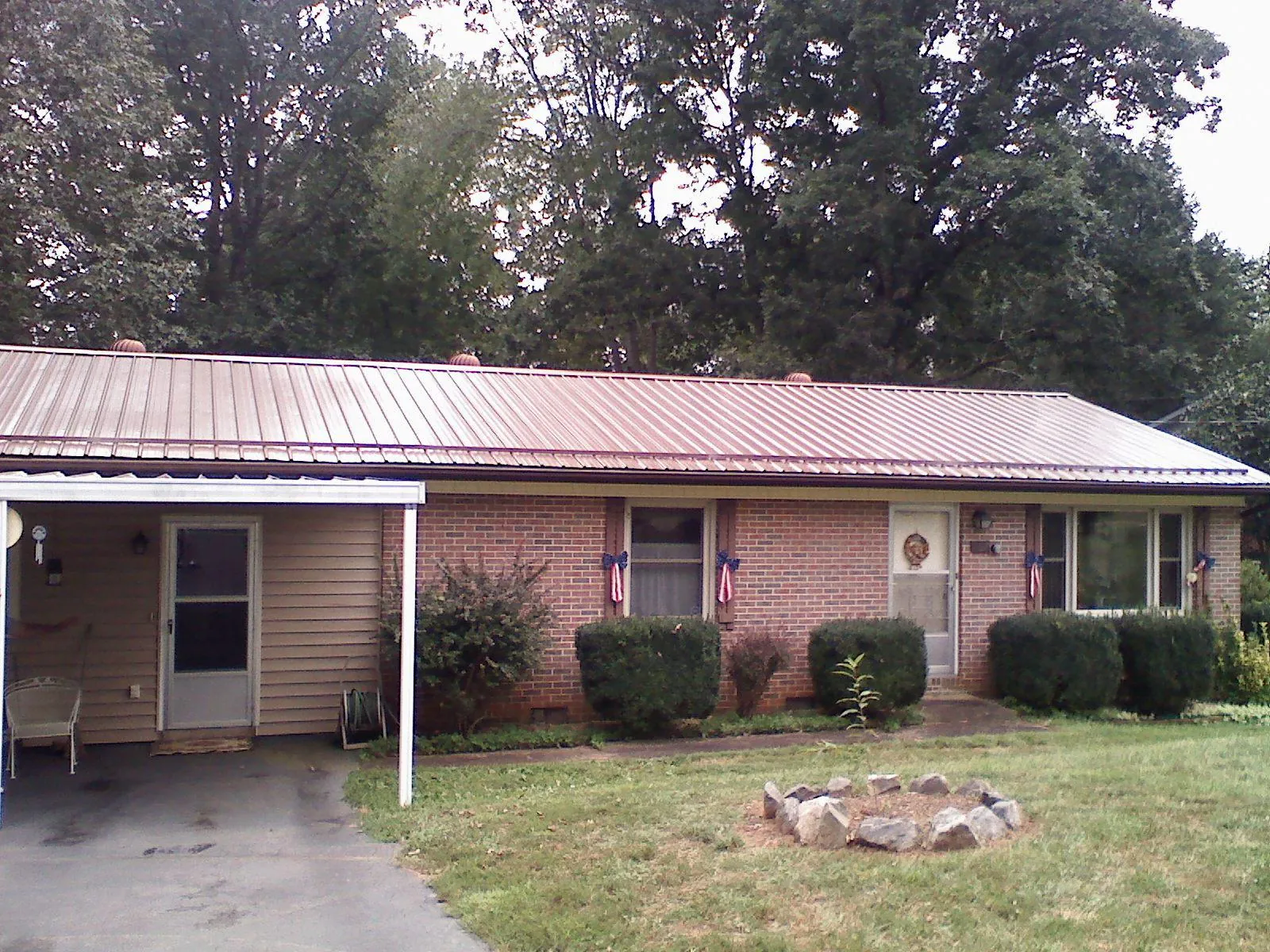 Bronze metal roof and carport on a brick ranch home — Roof Repair work by our crew in Verden